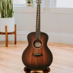 a guitar sitting on top of a hard wood floor