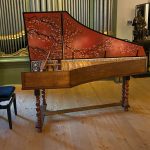 A grand piano in a room with wooden floors