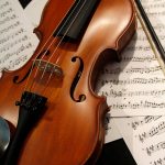a violin sitting on top of sheet music